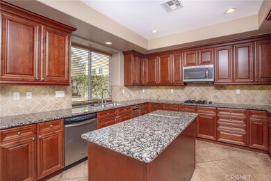 Other view of the kitchen..faucet handle with spray, trash compactor.  Lots of cabinets, counters and drawers.