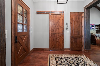 Entrance foyer with wood finished floors and a barn door