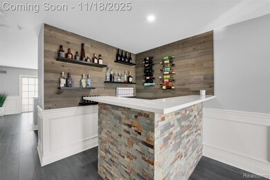 Indoor dry bar featuring wooden walls, wainscoting, a decorative wall, open shelves, and dark wood-type flooring
