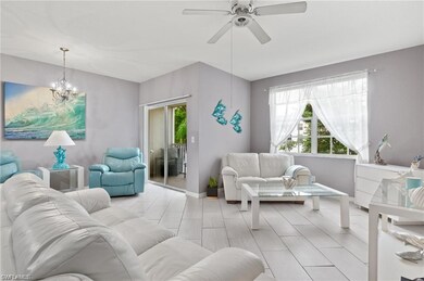 Living room featuring ceiling fan, a chandelier, and baseboards