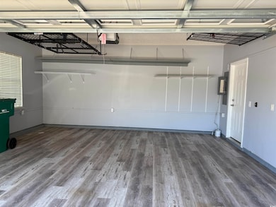 Garage featuring baseboards and a garage door opener