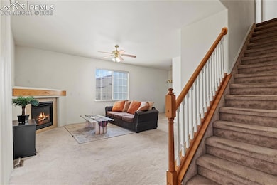 Living area featuring stairs, carpet flooring, a t