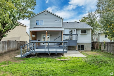 Rear view of property with a fenced backyard, a deck, a patio, and a shingled roof