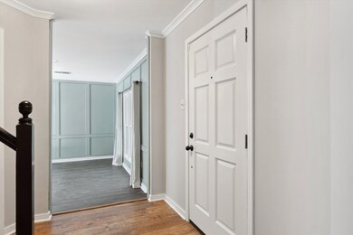 Hallway with wood finished floors, baseboards, orn