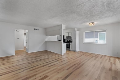 Unfurnished living room with light wood-type floo