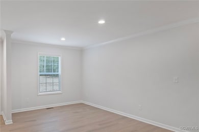 Unfurnished room with ornamental molding, light wo