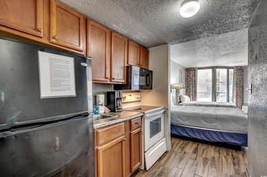 Kitchen with a textured ceiling, light hardwood / 