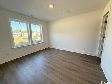 Empty room with dark wood-type flooring and baseboards