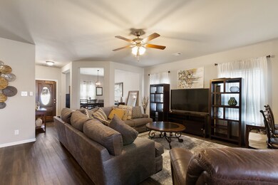This spacious family room is the heart of the home, complete with an upgraded ceiling fan and multiple windows with custom treatments.