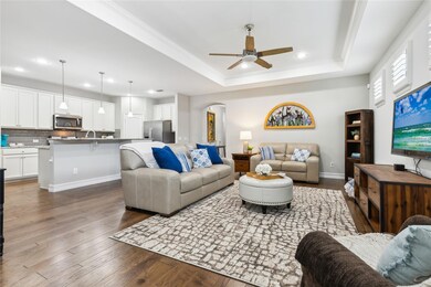 The spacious living room features a tray ceiling w
