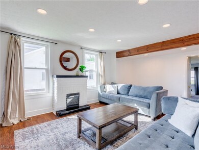 Living room featuring a textured ceiling, a brick fireplace, and dark wood-type flooring
