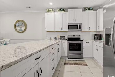 Kitchen featuring crown molding, white cabinetry, 