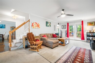 Living room w/ ceiling fan, carpet, and back porch