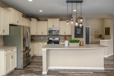 Custom cabinets, new back splash, stainless steel appliances, amazing grey paint, designer like wood laminate flooring.