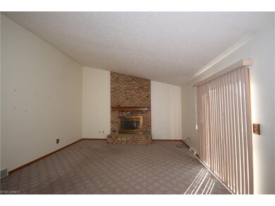 Vaulted great room features a brick fireplace and 