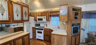 Kitchen featuring sink, hardwood / wood-style flooring, and white appliances