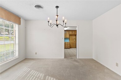 Spare room with a chandelier, light carpet, and a