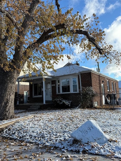 Ranch-style house featuring brick siding, a chimney, and covered porch