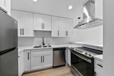 Modern kitchen with sleek white cabinetry, stainle