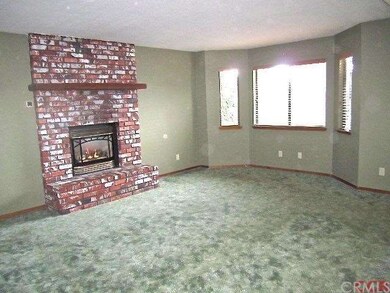 A great brick fireplace and bay window are feature