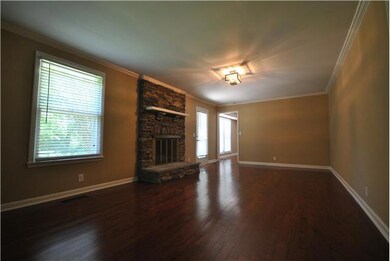 From the kitchen, you enter the den, which features a beautiful stone fireplace with gas logs, an elegant chandelier, and lots of natural light coming through the windows and patio door that overlook the private backyard paradise.