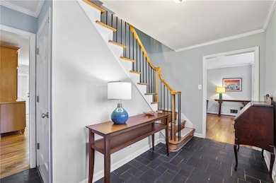 Staircase with crown molding and tile patterned flooring