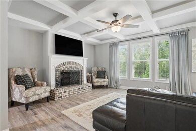 Living room featuring coffered ceiling, a fireplac
