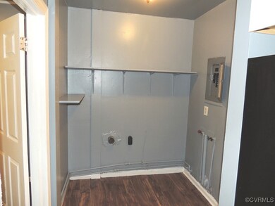 Laundry room with electric panel, wood finished fl