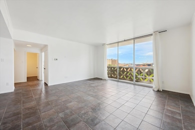 Living room featuring a wall of windows and dark tile patterned flooring / abundant Natural light