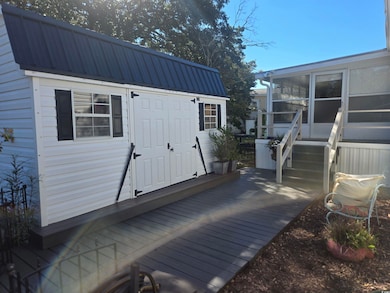 Wooden deck featuring a sunroom and an outbuilding