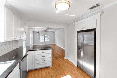 Kitchen with beamed ceiling, light hardwood / wood