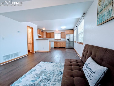 Living area featuring dark wood-style floors and baseboards