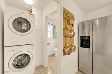 Laundry area with stacked washer / dryer, light ti