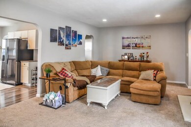 The living room has archways to the kitchen and ha