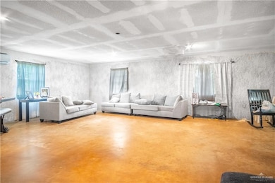 Living area featuring concrete floors and a wall mounted air conditioner
