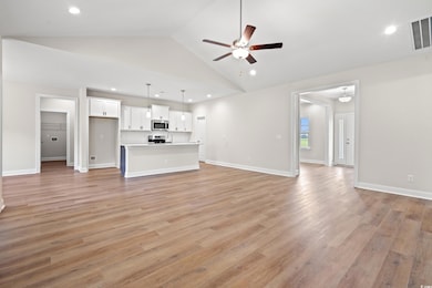 Unfurnished living room with ceiling fan, light wood-style floors, recessed lighting, and high vaulted ceiling
