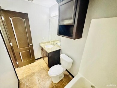 Bathroom featuring toilet, tile patterned flooring, and vanity