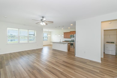 Unfurnished living room featuring a sink, light wo