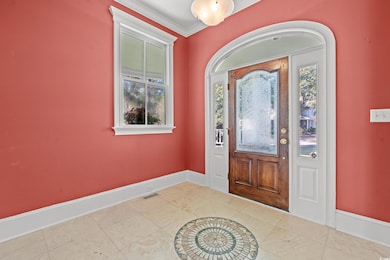 Foyer with light tile patterned flooring and ornam