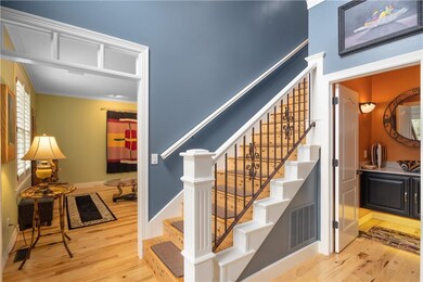 Entryway into the home showcases high ceiling and exquisite hardwood floors