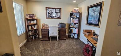 Office space with dark colored carpet and recessed lighting