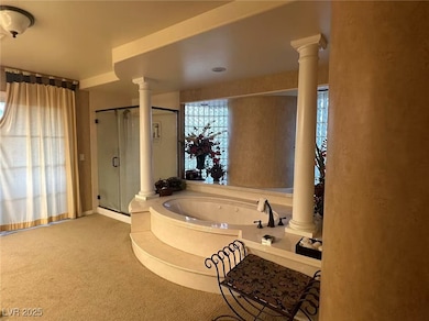 Bathroom with decorative columns, a stall shower,