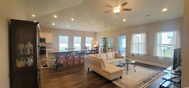 Living room featuring ceiling fan, sink, and dark 