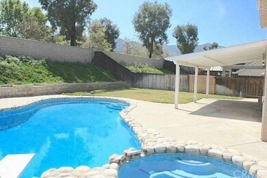 The backyard features a crystal blue swimming pool
