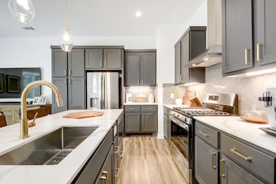 Stylish finishes include herringbone backsplash, stainless steel appliances, and designer pendant lighting.