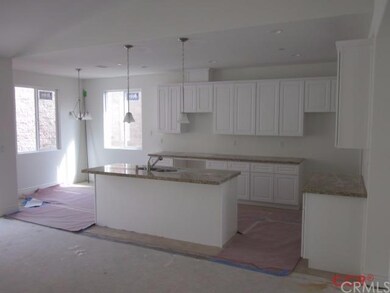 Kitchen features slab granite counter tops, island
