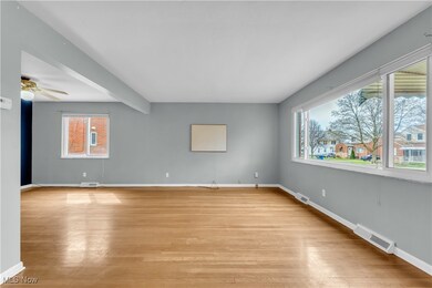 Unfurnished room featuring ceiling fan, light wood finished floors, baseboards, and visible vents
