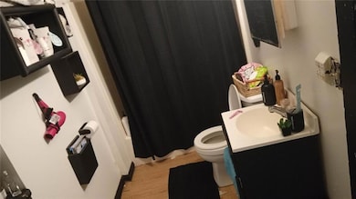 Bathroom with vanity, shower / bathtub combination with curtain, and light wood finished floors