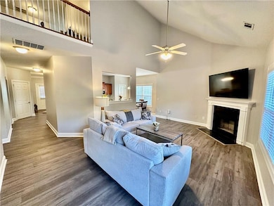Living area with a ceiling fan, baseboards, visibl
