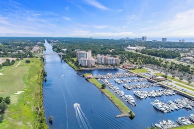 View of urban area with a nearby body of water and a tree filled landscape